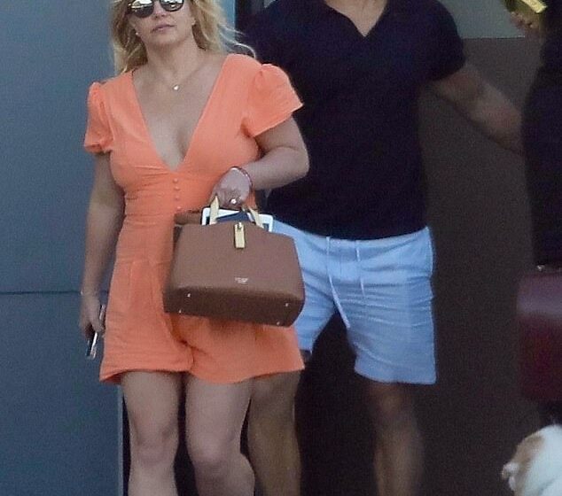  Britney Spears rocks an orange minidress on a rare outing with fiance Sam Asghari at to LAX